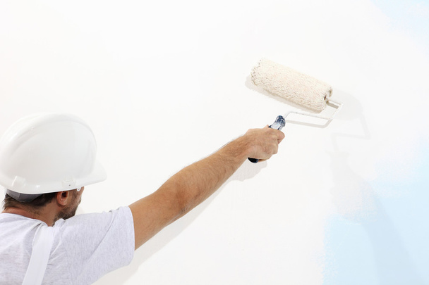 pintor hombre en el trabajo con un rodillo de pintura, concepto de pintura de pared
 - Foto, imagen
