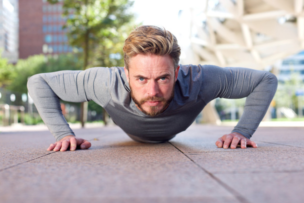 Fit man doing push ups outdoors - Foto, immagini