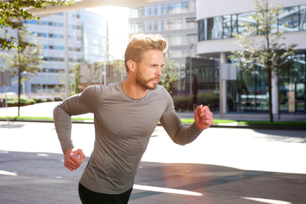 Aktivní sportovní muž běží mimo ve městě - Fotografie, Obrázek
