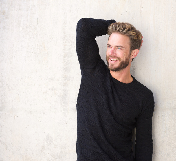 Sorridente modello di moda maschile in posa in maglione nero
 - Foto, immagini