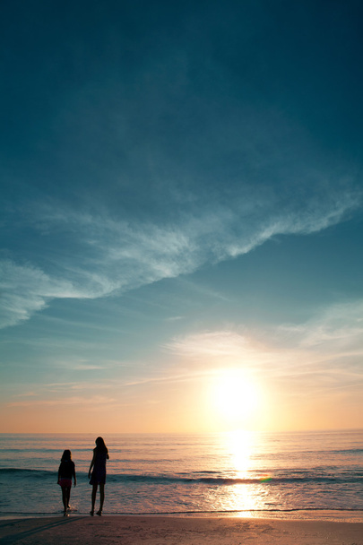 Две девушки на прекрасном пляже на закате
. - Фото, изображение