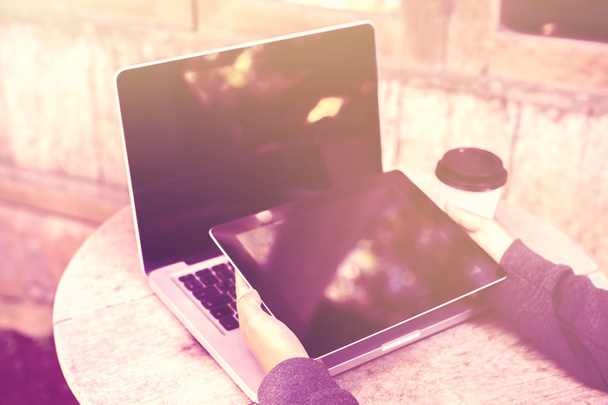 Mädchen mit digitalem Tablet, Coffee to go und Laptop auf dem Holztisch - Foto, Bild