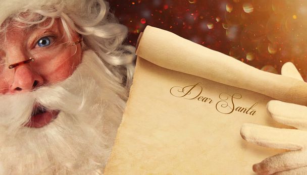 Fechar-se de Santa segurando um querido Papai Noel pergaminho
 - Foto, Imagem