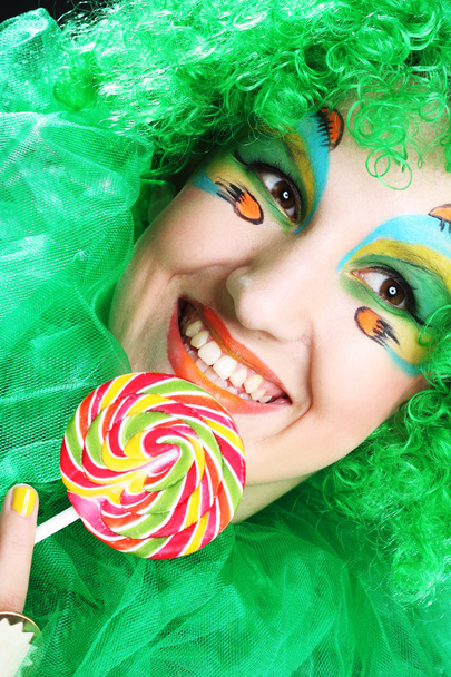 Girl with with creative make-up holds lollipop - Fotografie, Obrázek