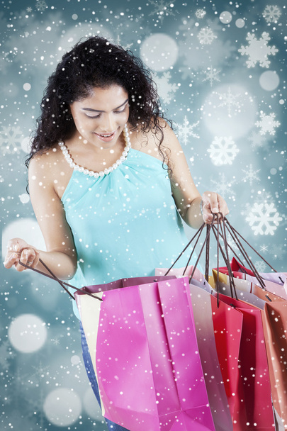 Woman opens shopping bags with winter background - Foto, imagen