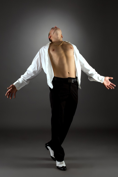 Artistic man dancing in studio, on grey backdrop - Valokuva, kuva