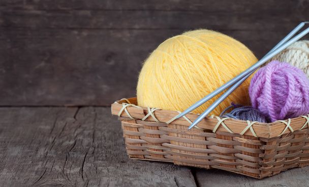 Balls of yarn in basket with knitting needles - Foto, Imagen