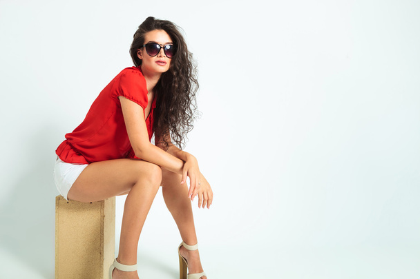 woman wearing sunglasses and heels while sitting with hands cros - Fotoğraf, Görsel