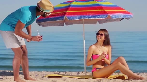 Το μάτσο φλερτάρει με ένα κορίτσι στην παραλία. - Πλάνα, βίντεο