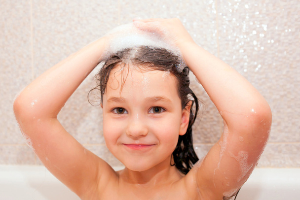 Niño feliz está lavando el cabello
 - Foto, imagen