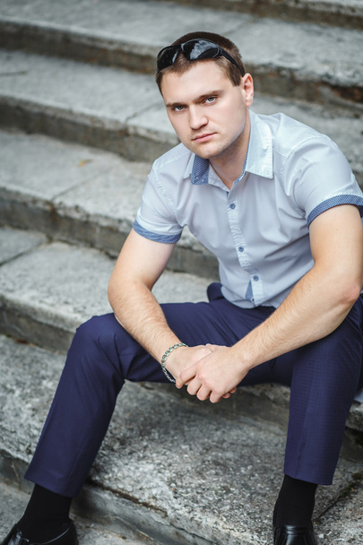 Handsome guy in blue shirt sitting - Photo, image