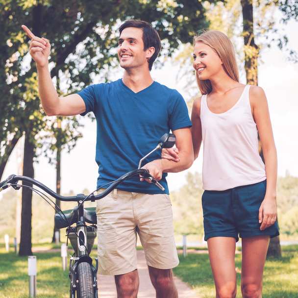 Couple à pied avec vélo dans le parc
 - Photo, image