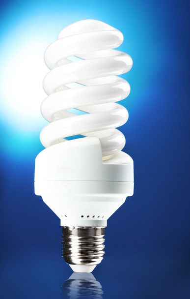 Energy saving lamp on blue background - Foto, afbeelding
