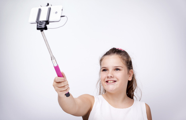 Little girl using a selfie stick - Photo, Image