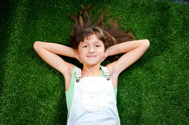 Little girl smiling on grass - Фото, изображение