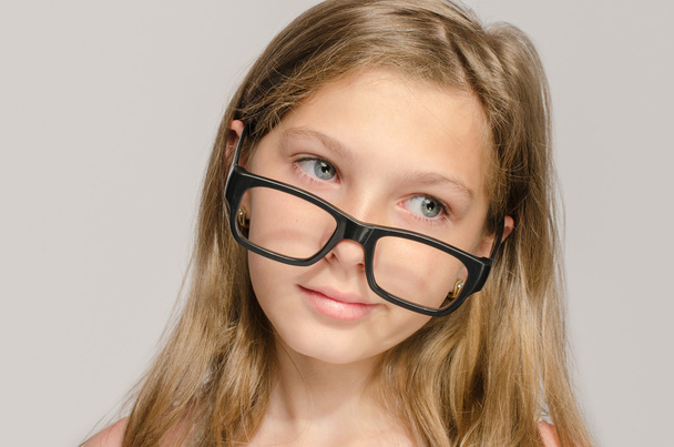 Beautiful little girl wearing big eyeglasses and looking smart - Foto, Imagen