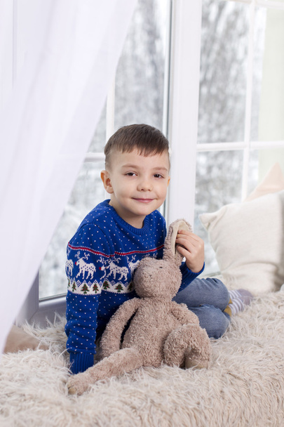 Retrato de un niño en un suéter azul
 - Foto, imagen