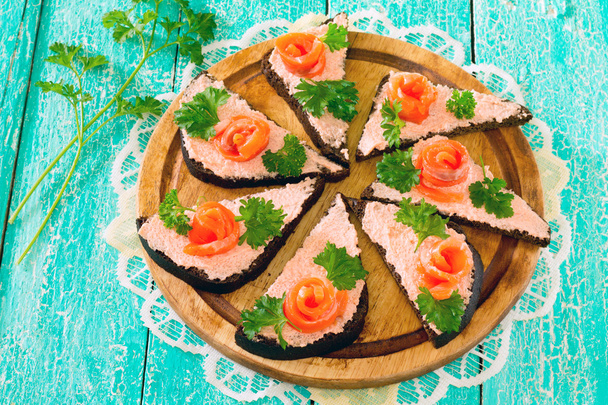 Broodjes roggebrood en rode vis op een houten tafel - Foto, afbeelding
