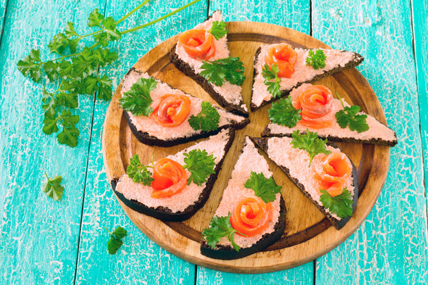 Sandwiches de pan de centeno y pescado rojo en una mesa de madera
 - Foto, Imagen