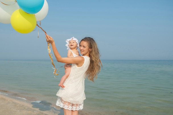 Happy beautiful mother and daughter enjoying beach time - 写真・画像