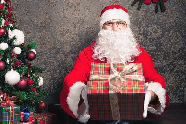 Santa Claus holding gift box or present at Christmas - Photo, image