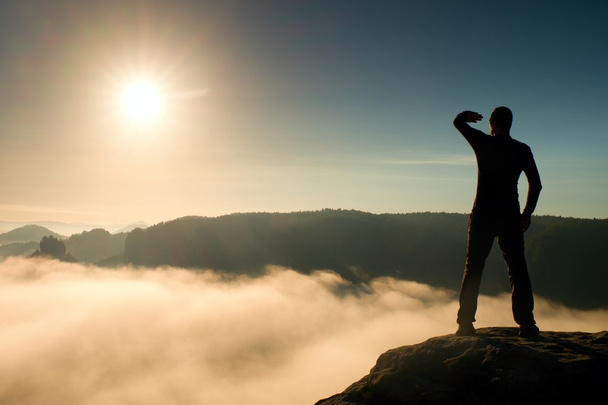 divertente ragazzo su rocs orologio oltre nebbioso oceano in mattina valle a sole
 - Foto, immagini