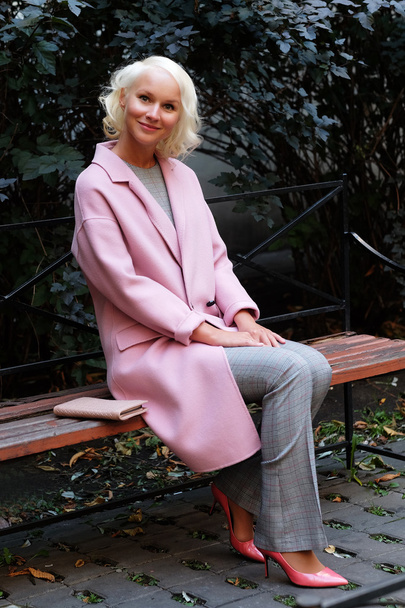 Style blond woman sitting on the bench - Foto, afbeelding