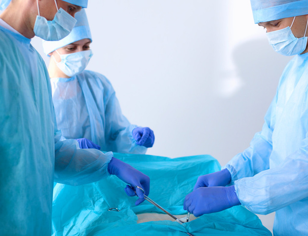 Ομάδα του χειρουργού σε ενιαία εκτέλεση λειτουργίας σε έναν ασθενή σε κλινική καρδιοχειρουργικής - Φωτογραφία, εικόνα