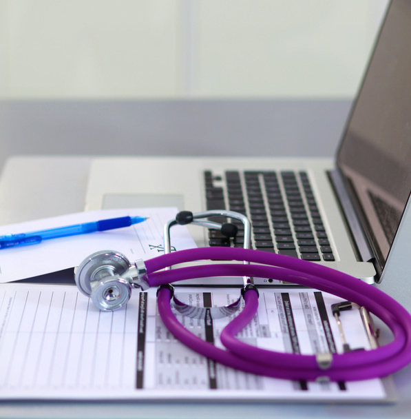 medyczny stetoskop w pobliżu laptopa na drewnianym stole, biały - Zdjęcie, obraz
