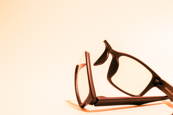 Крупним планом зламані пластикові окуляри на кольоровому фоні
 - Фото, зображення
