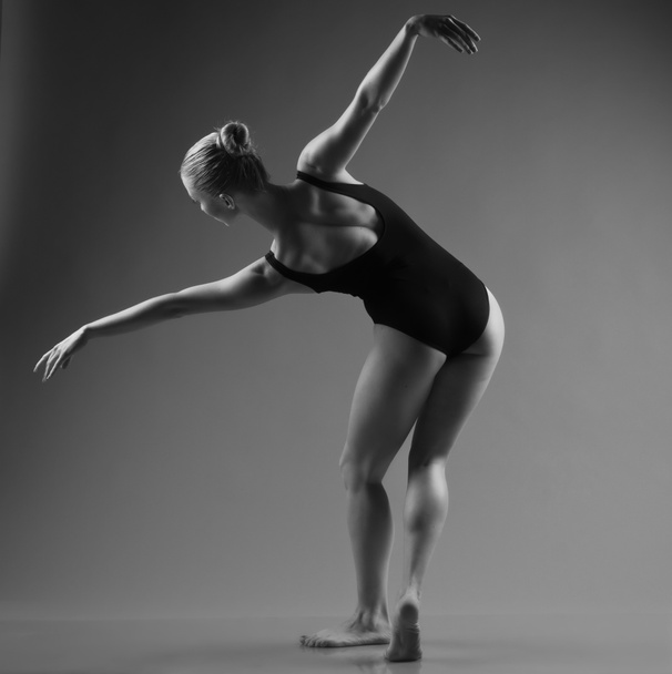 Moderne balletdanser poseren op donkere achtergrond - Foto, afbeelding