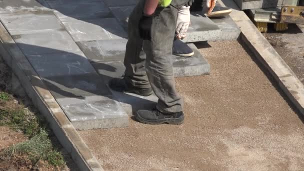 lavoratori clandestini uomini pavimentano piastrelle sul marciapiede. 4K
 - Filmati, video
