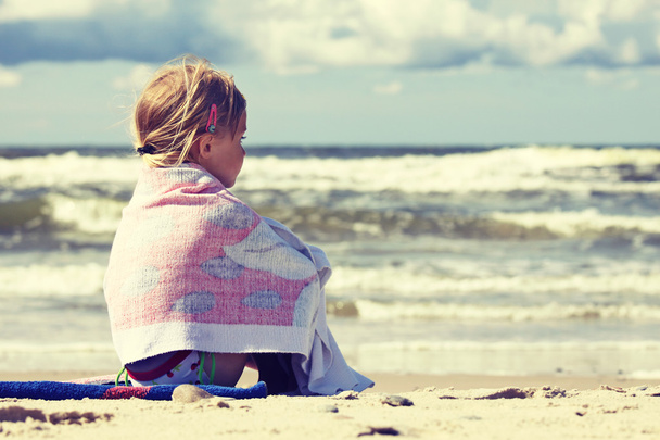 kleines Mädchen sitzt am Strand - Foto, Bild