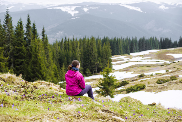 young caucasian woman sitting and enjoying the view in mountains - Fotografie, Obrázek