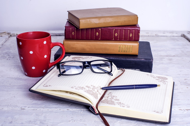books, notepad, cellphone and coffee cup on wooden background. Education concept - 写真・画像