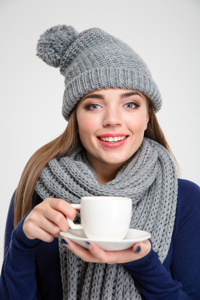 Woman wearing in scarf and hat holding cup with coffee - Valokuva, kuva