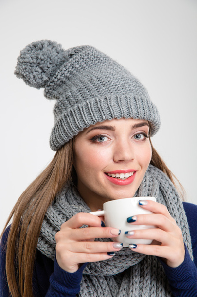 Smiling woman in winter cloth drinking coffee - Fotoğraf, Görsel