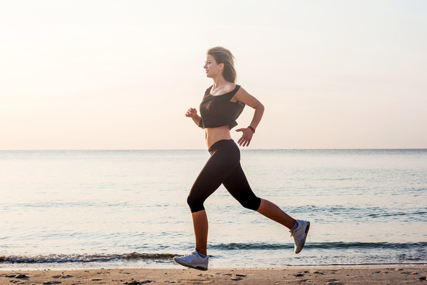 Donna in corsa. Femmina corridore jogging durante l'alba sulla spiaggia
. - Foto, immagini