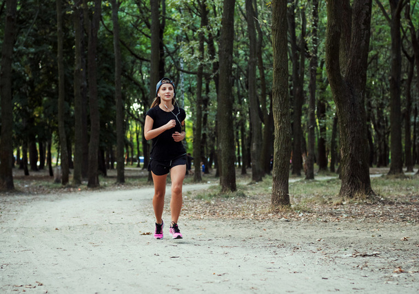 young caucasian female running in park. Female jogging in park - Valokuva, kuva