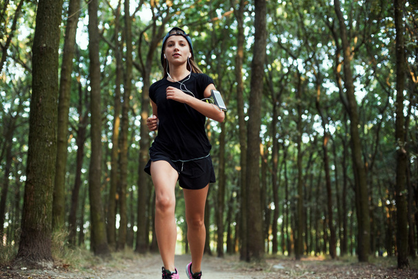 young caucasian female running in park. Female jogging in park - Zdjęcie, obraz