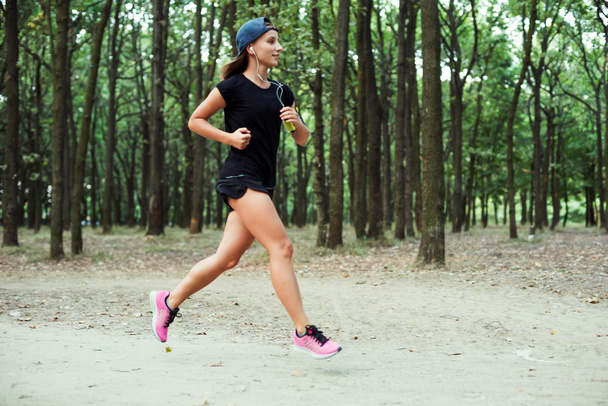 young caucasian female running in park. Female jogging in park - Zdjęcie, obraz