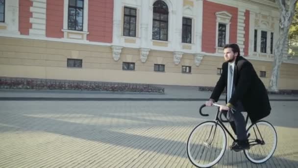 knappe zakenman een fiets in de oude stad - Video