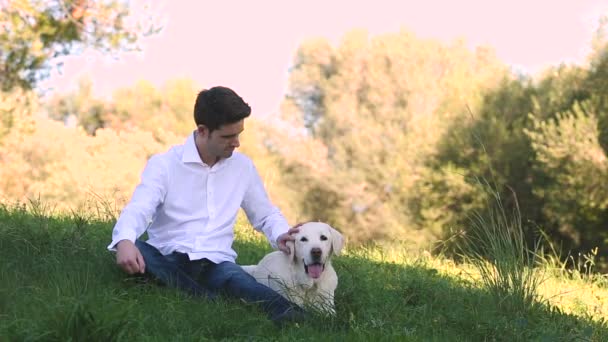 Junger Mann mit altem Labrador-Hund in der Natur - Filmmaterial, Video