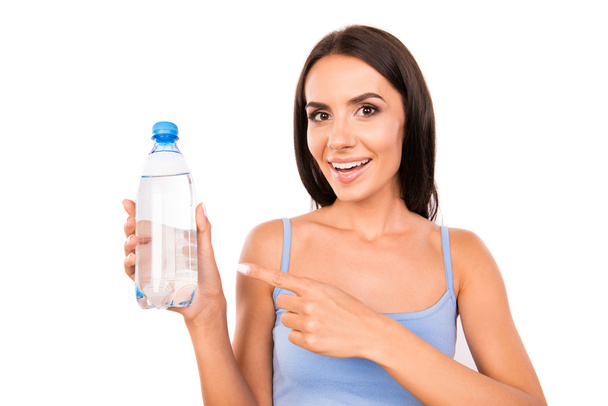 Slim pretty girl showing a bottle with water - Fotoğraf, Görsel