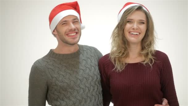 Ευτυχισμένο ζευγάρι με το καπέλο της Σάντα γελάει ενώ στέκεται σε μια αγκαλιά - Πλάνα, βίντεο