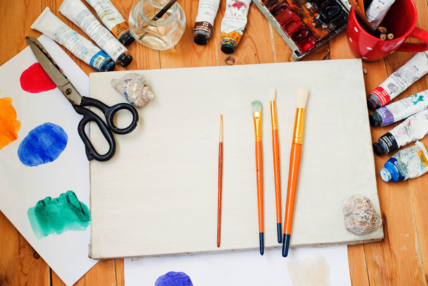 akwarela farby, farby olejne, telefon, okulary i szczotki na stole w studio artystyczne. - Zdjęcie, obraz