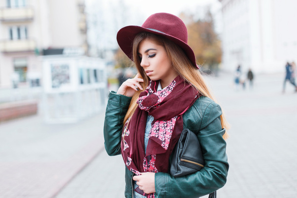 Bella ragazza con cappello, sciarpa e giacca sullo sfondo del trambusto della città
 - Foto, immagini