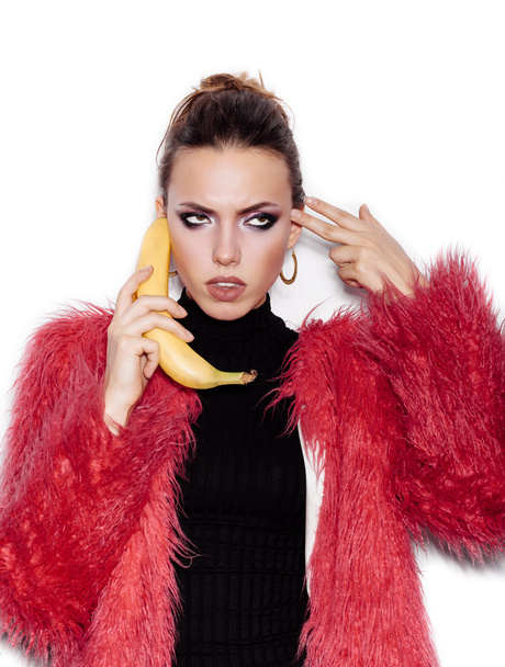Woman holding a banana as telephone and having fun - Foto, afbeelding