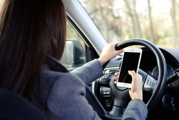 woman driving car and using smartphone - Фото, изображение