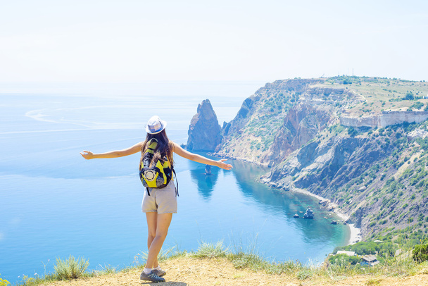 young caucasian female hiking on a cliff above the sea - Foto, afbeelding